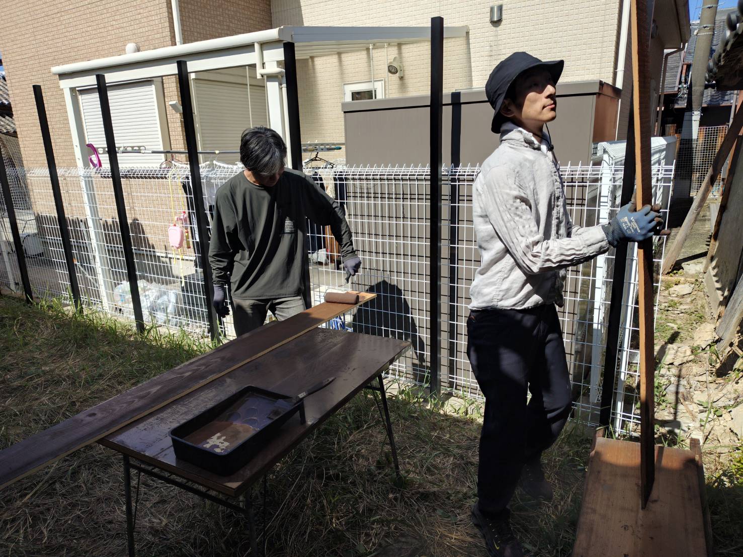 隠れ庭の壁に使う板をベンガラで色付けする作業